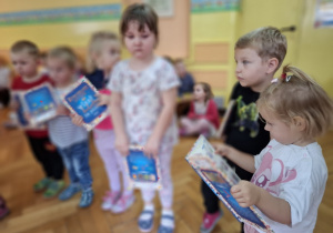 Nowo przyjęte dzieci trzymają w rękach otrzymane w prezencie książeczki