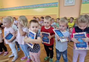 Nowo przyjęte dzieci trzymają w rękach otrzymane w prezencie książeczki