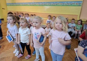 Nowo przyjęte dzieci trzymają w rękach otrzymane w prezencie książeczki