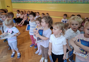 Nowo przyjęte dzieci trzymają w rękach otrzymane w prezencie książeczki