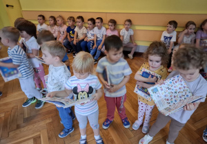 Nowo przyjęte dzieci trzymają w rękach otrzymane w prezencie książeczki