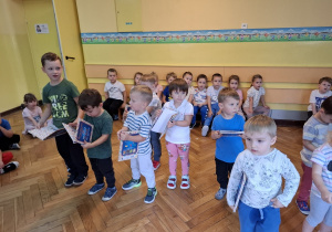 Nowo przyjęte dzieci trzymają w rękach otrzymane w prezencie książeczki