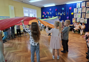 Dzieci z grupy trzeciej prezentują zabawę z chustą animacyjną