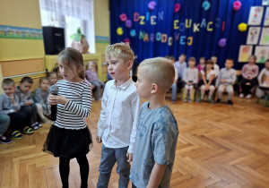 Troje dzieci recytuje wspólnie wiersz