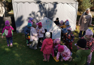 Dzieci kolorują kartonowy domek