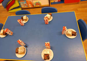 Na stoliku, na talerzykach naszykowany jest dla dzieci poczęstunek