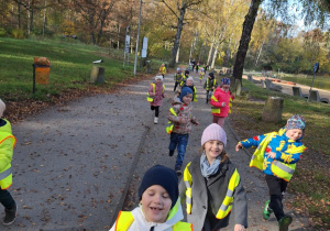 Grupa dzieci biegnie alejką