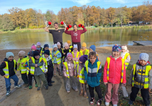 Dzieci pozują do zdjęcia z trenującymi bokserami nad stawem w Arturówku
