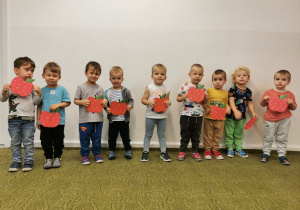 Dzieci pozują do zdjęcia z wykonanymi przez siebie jabłkami