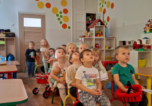 Dzieci jadą pociągiem z ustawionych przez siebie krzeseł