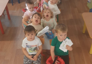 Dzieci jadą pociągiem z ustawionych przez siebie krzeseł