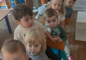 Dzieci jadą pociągiem z ustawionych przez siebie krzeseł