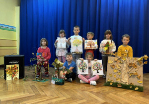 Grupa dzieci ze swoimi jesiennymi pracami plastycznymi