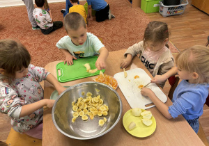 Dzieci kroją owoce na sałatkę