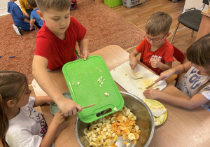 Dzieci przygotowują sałatkę owocową