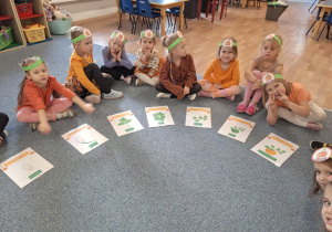 Dziewczynki siedzą na dywanie i uczestniczą w zabawie - Jak rośnie dynia