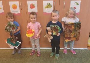 Grupa dzieci pozuje do zdjęcia z pracami wykonanymi wspólnie z rodzicami