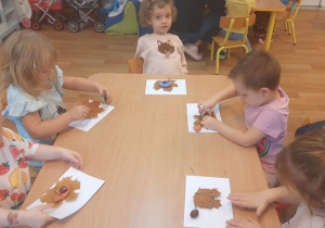 Dzieci wykonują pracę tematyczną na jesiennych warsztatach plastycznych