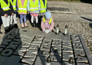 Dzieci zapalają znicz