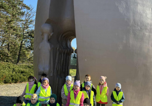 Grupa dzieci przed pomnikiem Pęknięte Serce