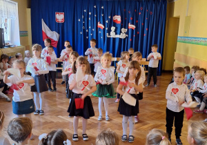 Dzieci z czwartej grupy tańczą z biało-czerwonymi chustkami
