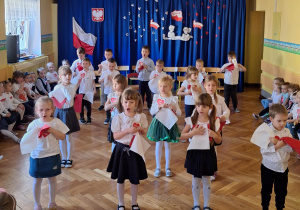 Dzieci z czwartej grupy tańczą z biało-czerwonymi chustkami