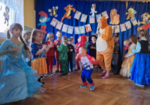 Dzieci tańczą na balu razem z panią