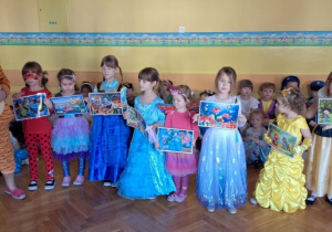 Dzieci pokazują ilustracje z różnych bajek