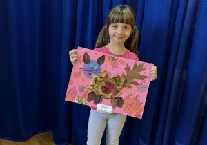 Dziewczynka z pracą plastyczną wykonaną z materiału przyrodniczego