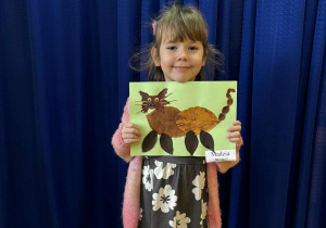 Dziewczynka z pracą plastyczną wykonaną z materiału przyrodniczego