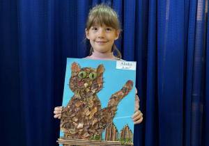 Dziewczynka z pracą plastyczną wykonaną z materiału przyrodniczego