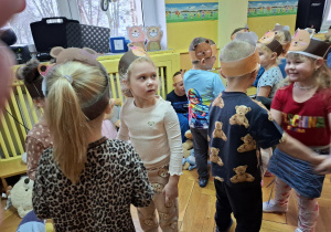 Dzieci w opaskach z misiami tańczą w parach do muzyki