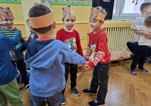 Chłopcy w opaskach z misiami tańczą w kole do muzyki