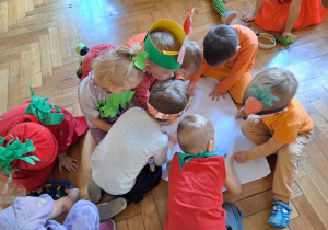 Grupa dzieci koloruje wielkoformatową kolorowankę