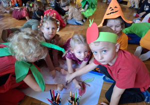 Grupa dzieci koloruje wielkoformatową kolorowankę