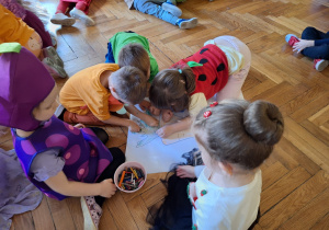 Grupa dzieci koloruje wielkoformatową kolorowankę