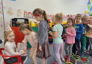 Grupa dzieci składa dziewczynce życzenia