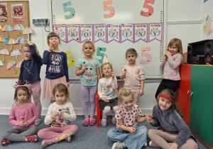 Grupa dziewczynek pozuje do zdjęcia z Laurą