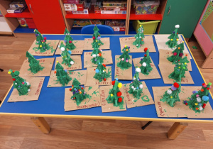 Wystawa na stole zrobionych przez dzieci choinek