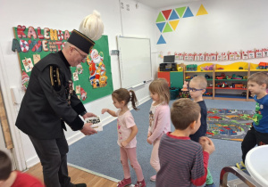 Górnik częstuje grupę dzieci cukierkami