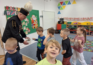 Górnik częstuje grupę dzieci cukierkami