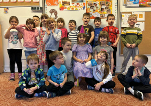 Dziewczynka w urodzinowej czapeczce z kolegami z grupy