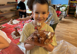 Cłopiec pokazuje wykonanego przez siebie renifera