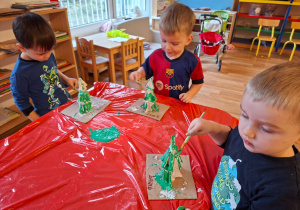Dzieci wykonują choinkę z gipsowych elementów