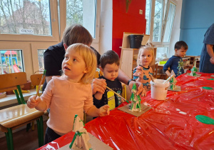 Dzieci wykonują choinkę z gipsowych elementów