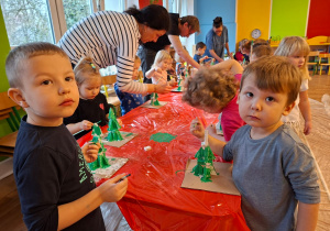 Dzieci wykonują choinkę z gipsowych elementów