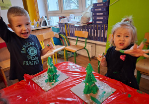 Dzieci wykonują choinkę z gipsowych elementów
