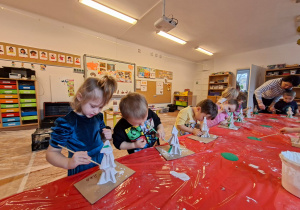 Dzieci wykonują choinkę z gipsowych elementów