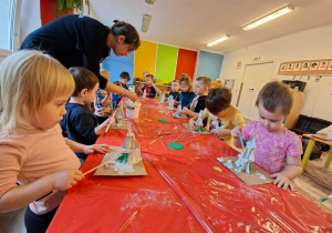 Dzieci wykonują choinkę z gipsowych elementów