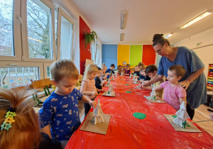 Dzieci wykonują choinkę z gipsowych elementów